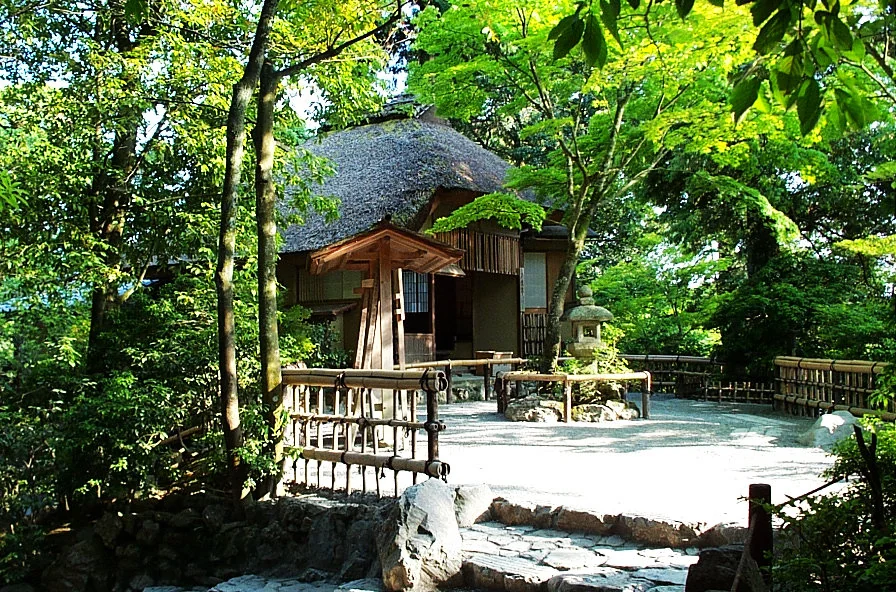 金閣寺園區中的茅草屋頂小建築與綠樹