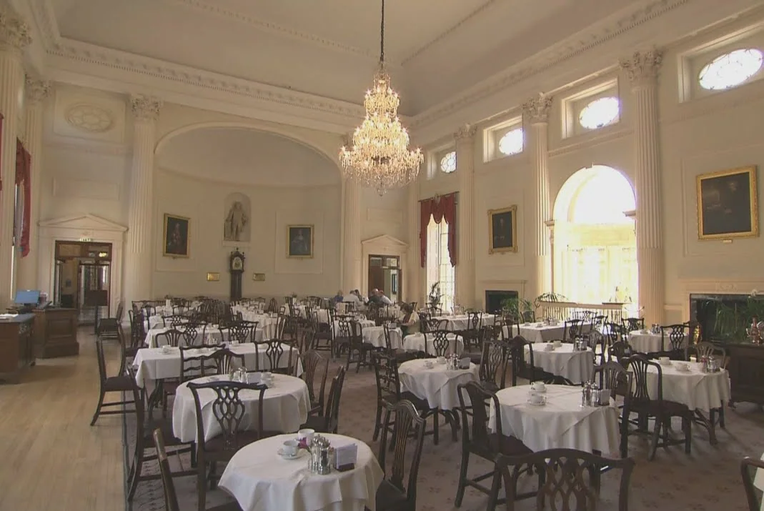 Pump Room 餐廳內部，桌椅鋪著白色桌巾。