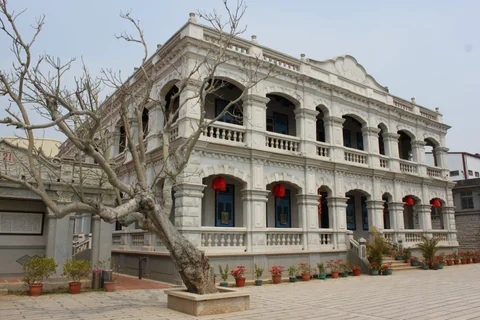 庭院老樹前方的陳景蘭洋樓側面拱廊與紅燈籠