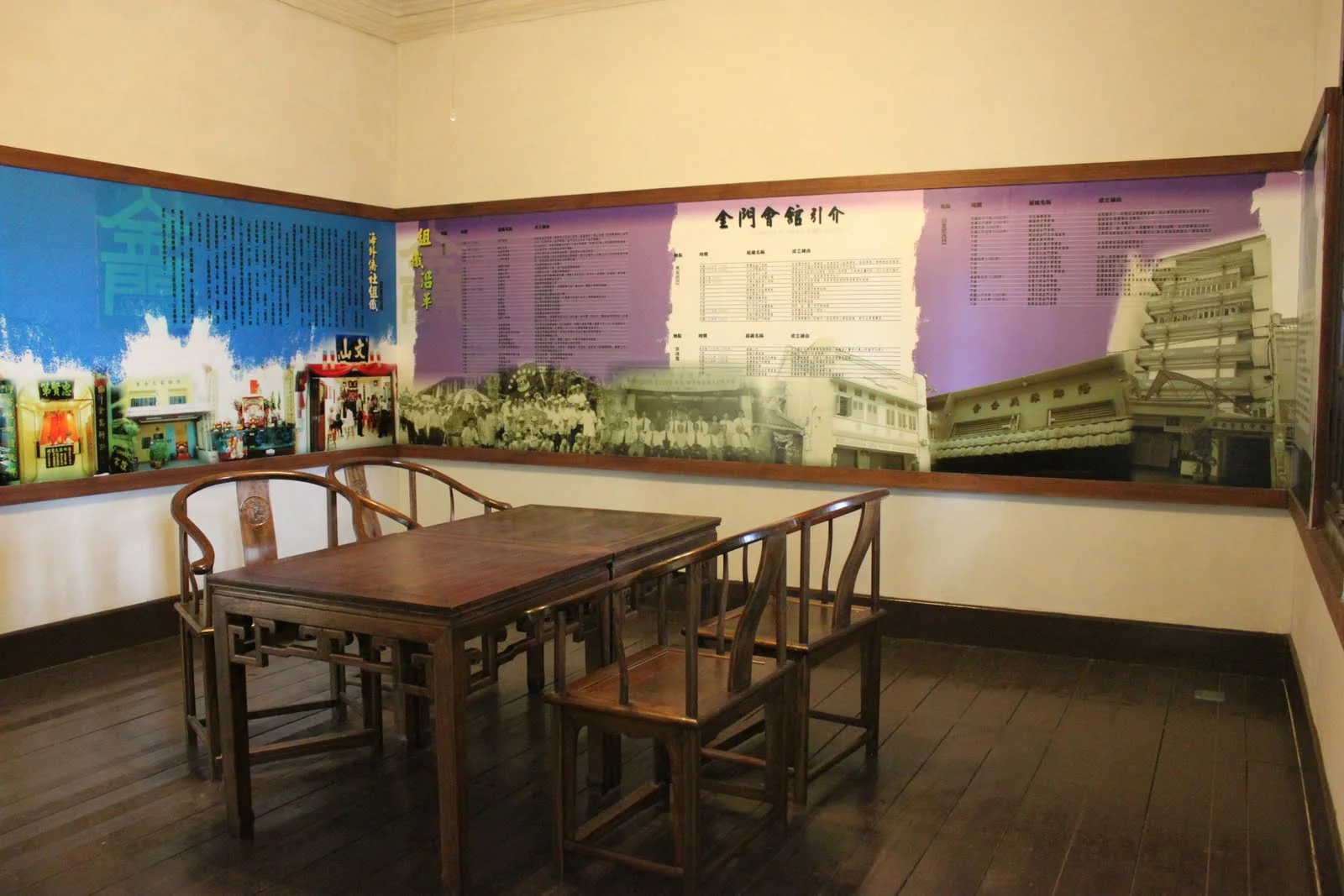 牆面家族史展示與中央傳統木桌椅的室內展間