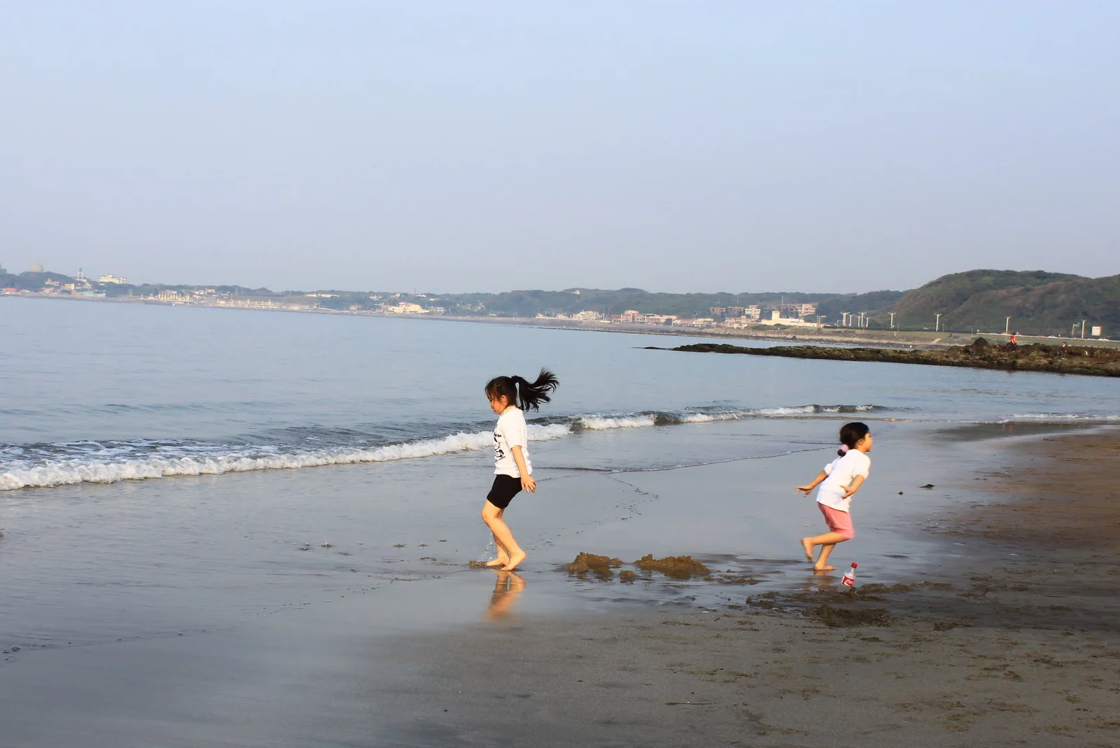 孩子在麟山鼻海邊的淺水區玩耍